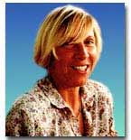 Headshot of Camboni against a blue background. Camboni is wearing a floral shirt and her hair sweeps across her forehead.