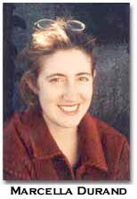 color photograph of Marcella Durand in a red shirt with hair pulled back and glasses on their head.