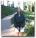 Wasserman is stood outside. She is wearing white shorts and a jacket. A path is stretching out behind her.