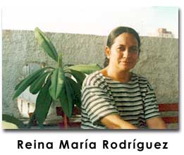 Reina María Rodríguez in a striped shirt next to a plant