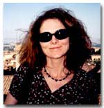 Headshot of Elizabeth Willis. She is wearing sunglasses and a beaded necklace. 