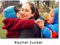 A photo of Zucker looking toward the camera as her children in bright outfits climb on her